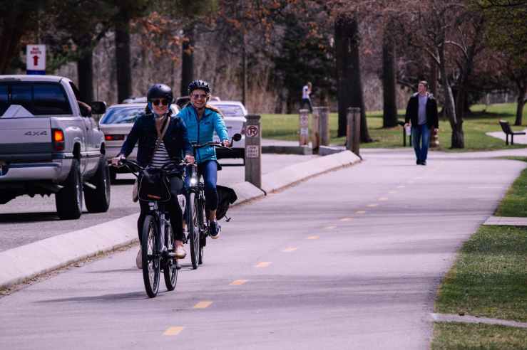 Two women riding towards the viewer on their bikes in casual clothing on a journey about town